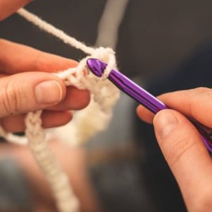 mujer aprendiendo a tejer crochet desde cero