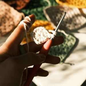 mujer tejiendo granny square a crochet